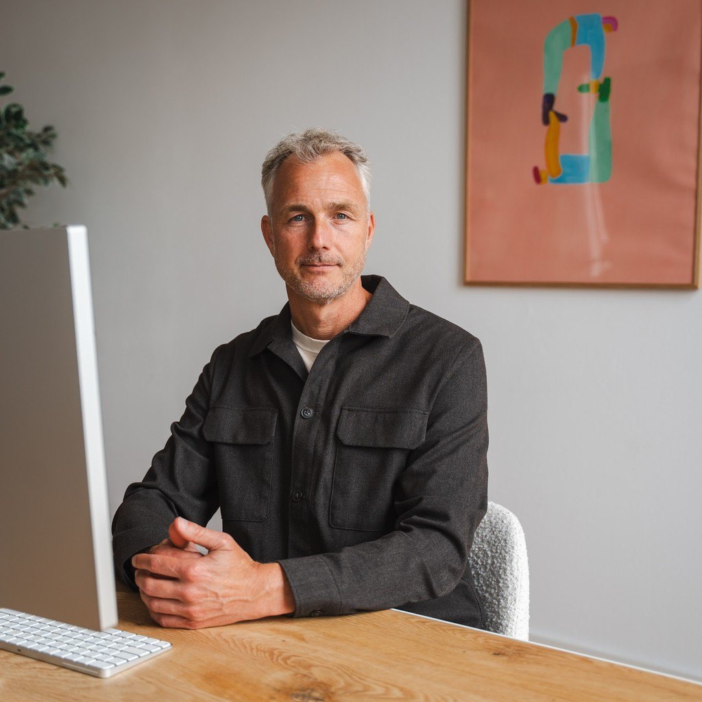 Mischa aan zijn bureau, achter de iMac